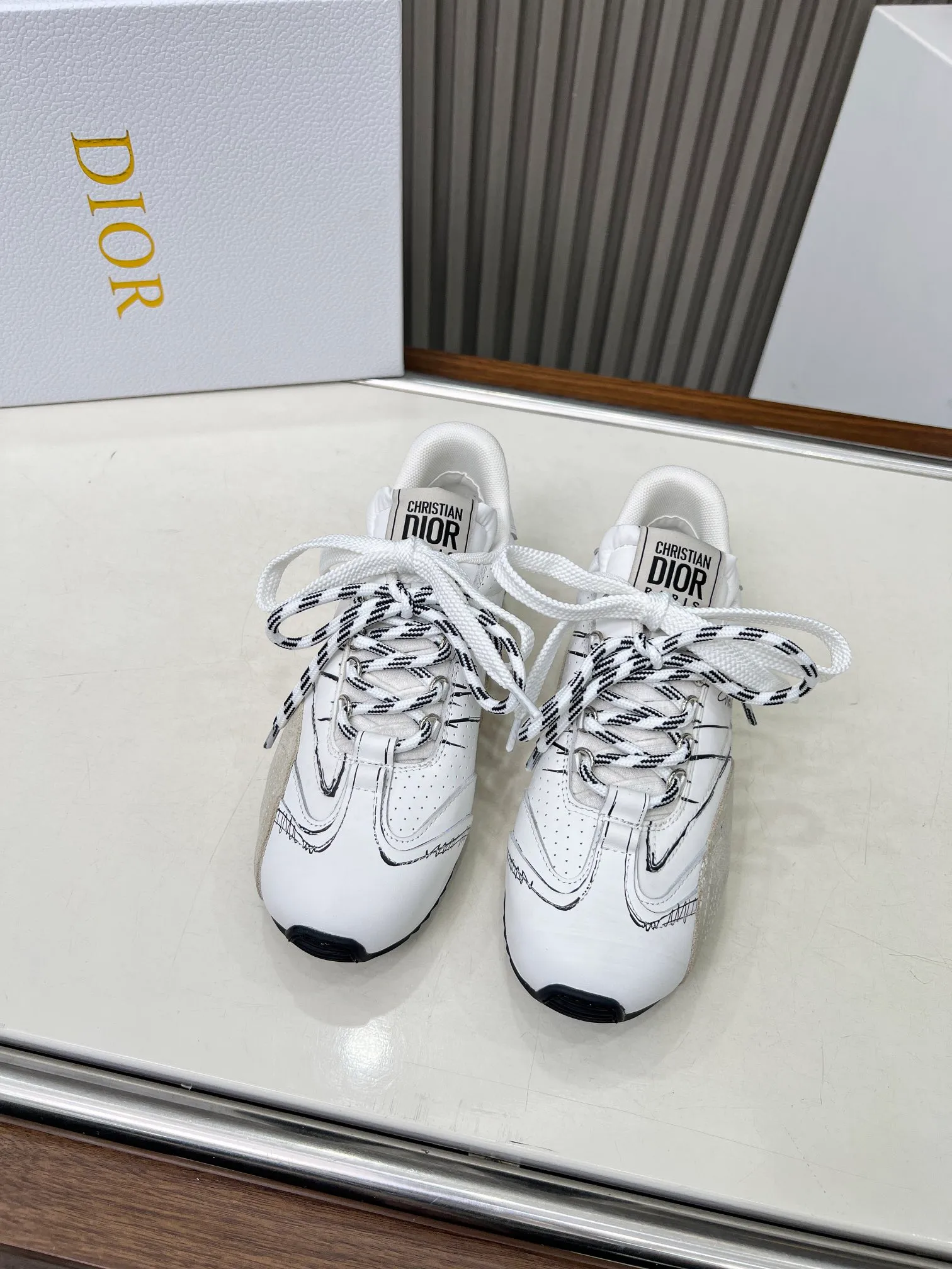 👟👟Ex-factory price 560👟👟 This D-Sketch sneaker is a new product of the 2025 spring and summer ready-to-wear series, highlighting the classic retro aesthetics. Crafted from gold-tone crinkled sheepskin and gold-toned laminated calfskin, it features a printed logo inspired by the shoe's production stages, as well as beige suede calfskin panels and double laces. Hand-written Christian Dior Paris signature on the side, Christian Dior Paris signature panels and plaques on the heel and tongue. Paired with two-tone slim rubber soles, they add a touch of couture to any casual look. Code number: 35~45 Color: black white gold silver